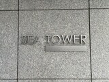 ザ東京タワーズシータワー グレー色の大理石張りの壁面に刻まれた建物名標識の様子
