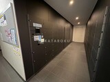 ザ東京タワーズシータワー 宅配ボックスが整列した落ち着いた印象の共用廊下