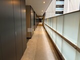 ザ東京タワーズシータワー モダンな設えの共用廊下、左側に複数のドアが並び奥へ続く様子