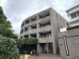 JMFレジデンス世田谷三宿 曲線的なバルコニーとレンガ調タイルの外壁が特徴の建物外観