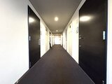 JMFレジデンス世田谷三宿 複数の黒いドアが並ぶモダンな印象の共用廊下
