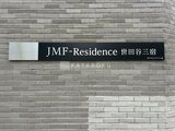 JMFレジデンス世田谷三宿 グレー系タイルの外壁に設置された建物名標識