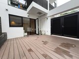 JMFレジデンス世田谷三宿 ウッドデッキのテラスと黒いシャッター門