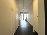 JMFレジデンス世田谷三宿 玄関から居住空間へ続く明るい廊下と落ち着いた色合いの床材
