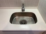 JMFレジデンス世田谷三宿 ステンレス製のシンクと白いカウンタートップのキッチン