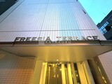 フリージアテラス 下から見上げた建物外観と明るく照らされたエントランス部分