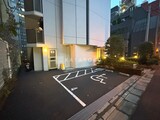 フリージアテラス 夜間照明に照らされた建物エントランスと駐車スペース
