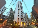 フリージアテラス 街並みに調和するモダンな高層マンションの夕景外観