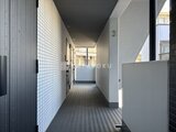 グランパセオ清澄白河 モダンなタイル張りの共用廊下から採光窓を通す明るい通路空間
