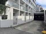 イプセ学芸大学 白を基調としたモダンな建物外観と駐車場入口の様子
