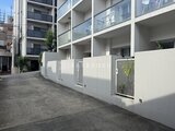 イプセ学芸大学 モダンな白壁に囲まれた、開放的な駐車場からの建物外観
