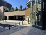 グランドシティタワー月島 駐車場入口とモダンなデザインの共用部が見える建物外観