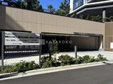 グランドシティタワー月島 機械式駐車場と案内看板がある建物前面の共用スペース