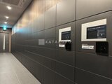 グランドシティタワー月島 モダンな壁面パネルと宅配ボックスが設置された共用廊下