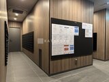 グランドシティタワー月島 木目調パネルと黒板が設置された共用部の廊下空間