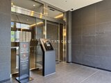 グランドシティタワー月島 モダンな石貼りの壁と照明が落ち着いた印象のエントランスホール