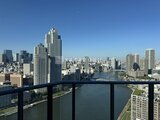 グランドシティタワー月島 高層階のバルコニーから見た川と都心の街並み