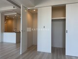 グランドシティタワー月島 開放感のあるリビングダイニングから見たキッチンと洋室への動線