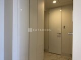グランドシティタワー月島 落ち着いた色合いのエレベーターホールから玄関へ続く廊下