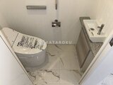 グランドシティタワー月島 トイレと手洗いカウンターが並ぶコンパクトな洗面室の俯瞰図