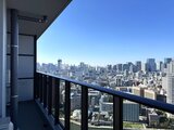 グランドシティタワー月島 高層階からの開放的なバルコニーと都市パノラマの眺め