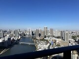 グランドシティタワー月島 高層階からの眺望、川を挟んで広がる都市風景と晴天の空