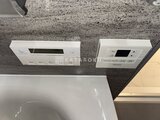 グランドシティタワー月島 トイレに設置された温水洗浄便座と壁付けリモコンパネル