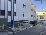 ドゥーエ参宮橋 モダンなタイル張りの建物外観と駐車場入口の様子
