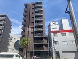 ブライズ大森本町 茶色系タイルの外壁にバルコニーを備えたモダンな建物外観