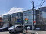 G-FLAT 青空の下、駐車場を備えたガラス張りのモダンな建物外観