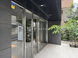 クレイシア亀戸サウスコート モダンなエントランスから見た建物正面と緑が映り込む様子