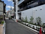 ザ・パークハビオ北千住 白い外壁と緑の植栽が映える建物の側面