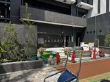 ザ・パークハビオ北千住 建設中の外観、モダンな黒基調の建物と工事用安全柵が見える様子