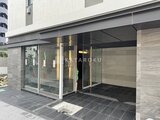 アイフラット品川戸越パークサイド 大きなガラス窓と開放的なエントランスを備えた建物の玄関部分