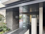 アイフラット品川戸越パークサイド モダンな石張り仕上げのエントランスから見た建物正面