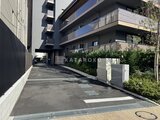 ブランシエスタ目黒中央町 モダンな集合住宅の駐車場入口から見た建物外観と緑化スペース