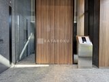 ブランシエスタ目黒中央町 モダンな共用ロビーの木目調ドアとエレベーター入口の様子