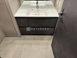 ブランシエスタ目黒中央町 黒い洗面台とシンプルな洗面器が備わった洗面室