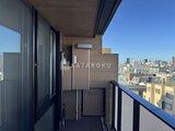 ブランシエスタ目黒中央町 都市風景を望むバルコニーに設置された室外機と物干し竿
