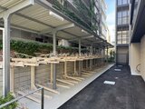 RJRプレシア蒲田 自転車置き場とアプローチが整備された開放的な共用部の様子