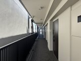 RJRプレシア蒲田 明るい印象の共用廊下、奥に玄関ドアが並ぶ様子