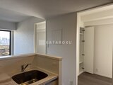 RJRプレシア蒲田 キッチンカウンターと奥に続く洋室入口が見える明るい空間