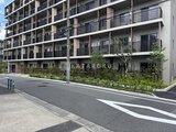 ロイジェント西新井 前面道路から見たモダンな外観と緑豊かなランドスケープ