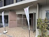 ロイジェント西新井 モダンな外観の建物エントランスと植栽が配置された開放的な共用