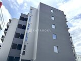 ロイジェント西新井 モダンな外観の多層建築物を下から見上げた様子