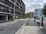 ロイジェント西新井 開放的なアプローチから見た建物外観と駐車場の様子