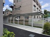 ロイジェント西新井 白いフレームのカーポートと整備された駐車スペースの様子