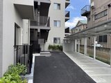 ロイジェント西新井 モダンな建物に隣接した、ゆとりのある共用駐車場の様子