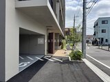 ロイジェント西新井 エントランス前の駐車場から建物入口を見た開放的な共用部の様子