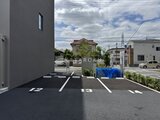ロイジェント西新井 駐車場から周辺道路を見た開放的な外構の様子
